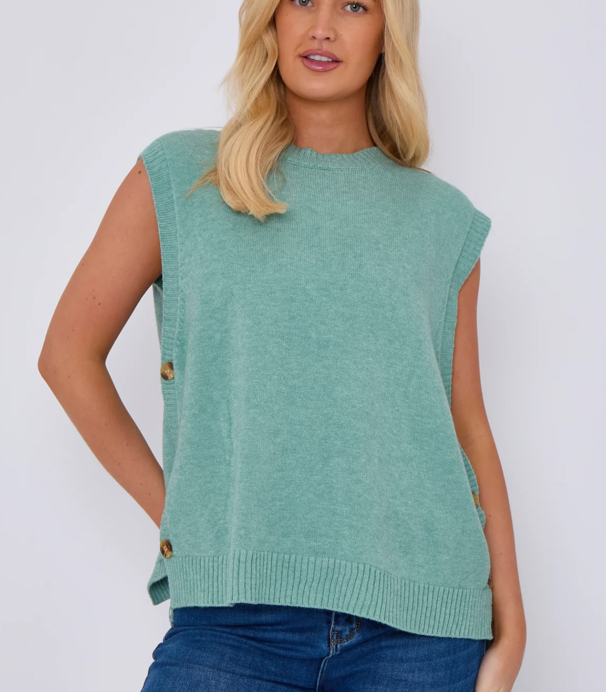 model wearing knitted vest with side buttons and round neck in cornflower blue