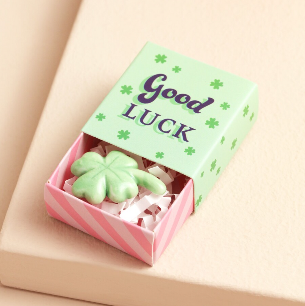 Green clover ceramic charm in a small good luck matchbox