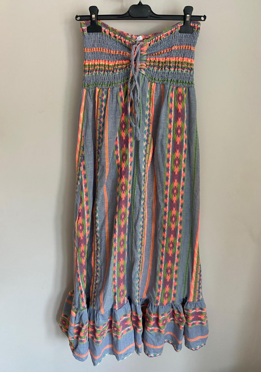photo of an Aztec print shirred bandeau or halterneck dress or skirt in denim blue and neon colours 