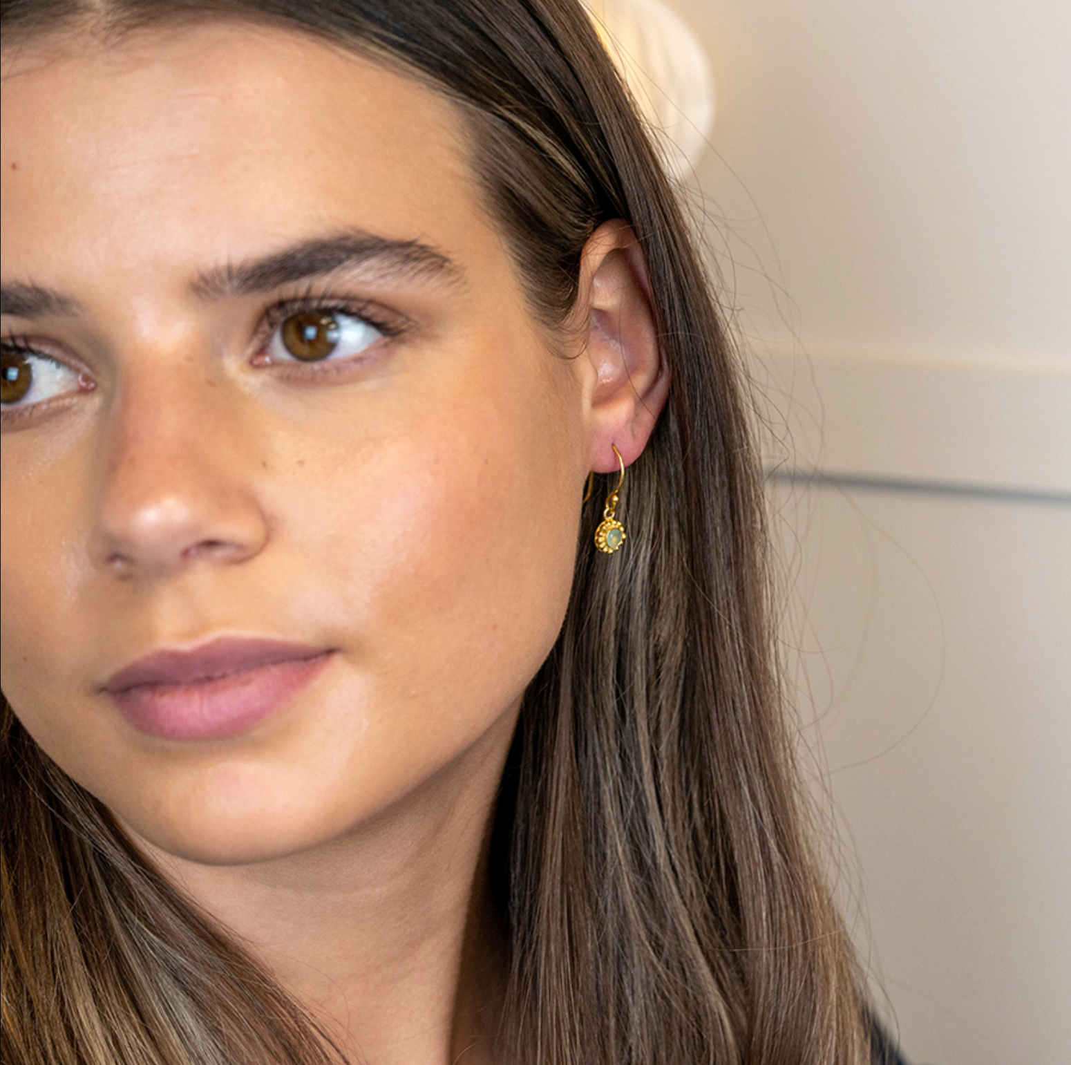 model wearing gold plated drop earrings with aqua gemstone in chalcedony