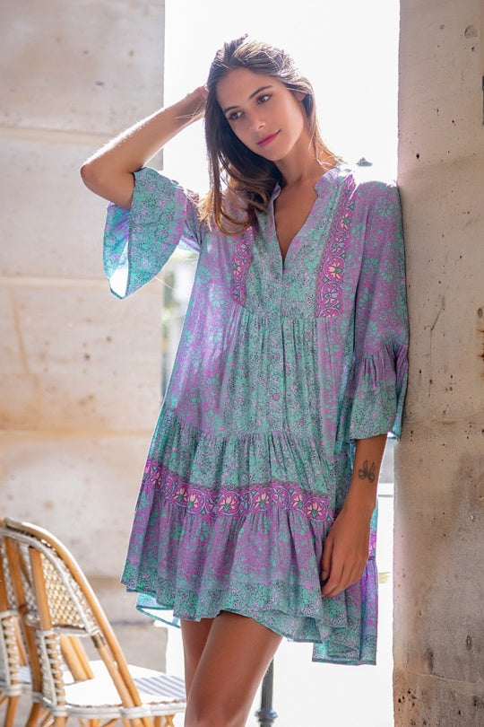 model wearing short tunic dress in purple and turquoise boho print