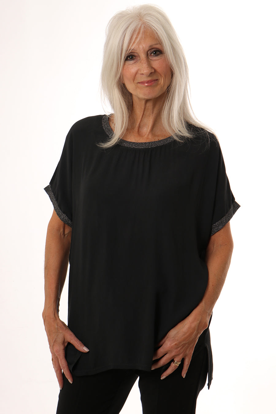 Model wearing dark grey short sleeve top with metallic trim on neck and sleeves