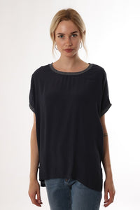 Model wearing navy short sleeve top with metallic trim