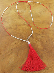 Thin long bead necklace with red tassel 