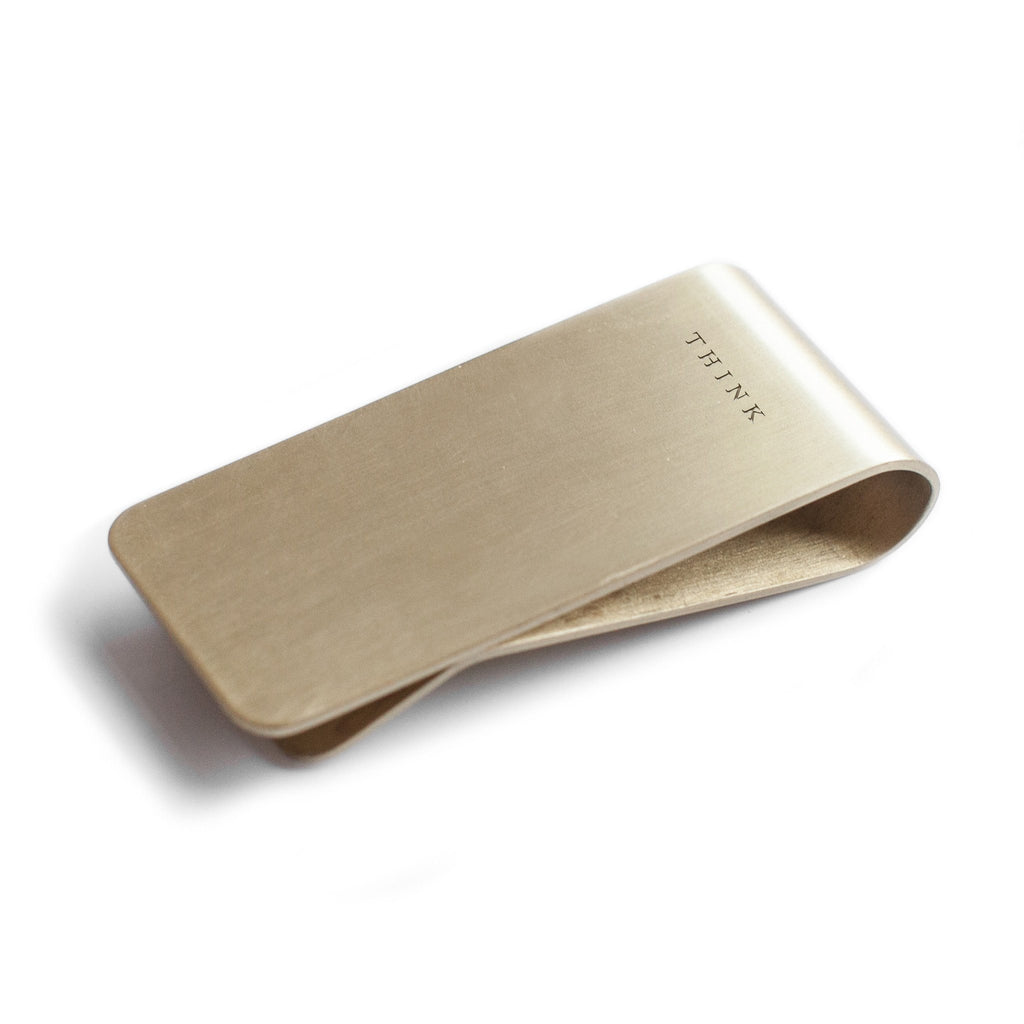 Brass money clip with think engraved on the front 