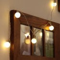 Warm white mini festoon lit fairy lights hanging over wood mirror