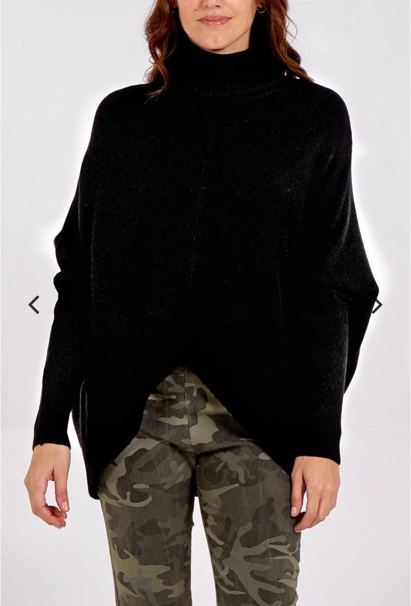 Model wearing black roll neck v hemline jumper and camo joggers