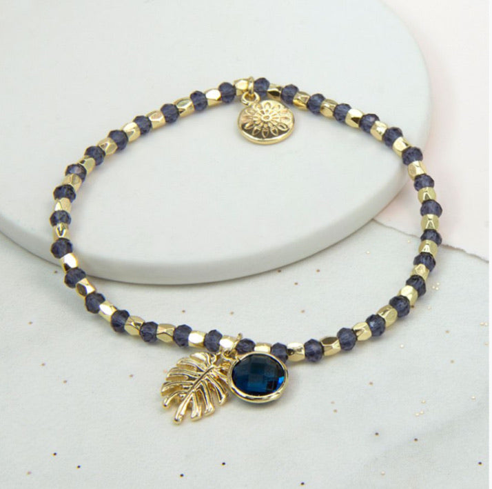 Gold and navy blue stretch bead bracelet gold palm leaf and blue crystal charm