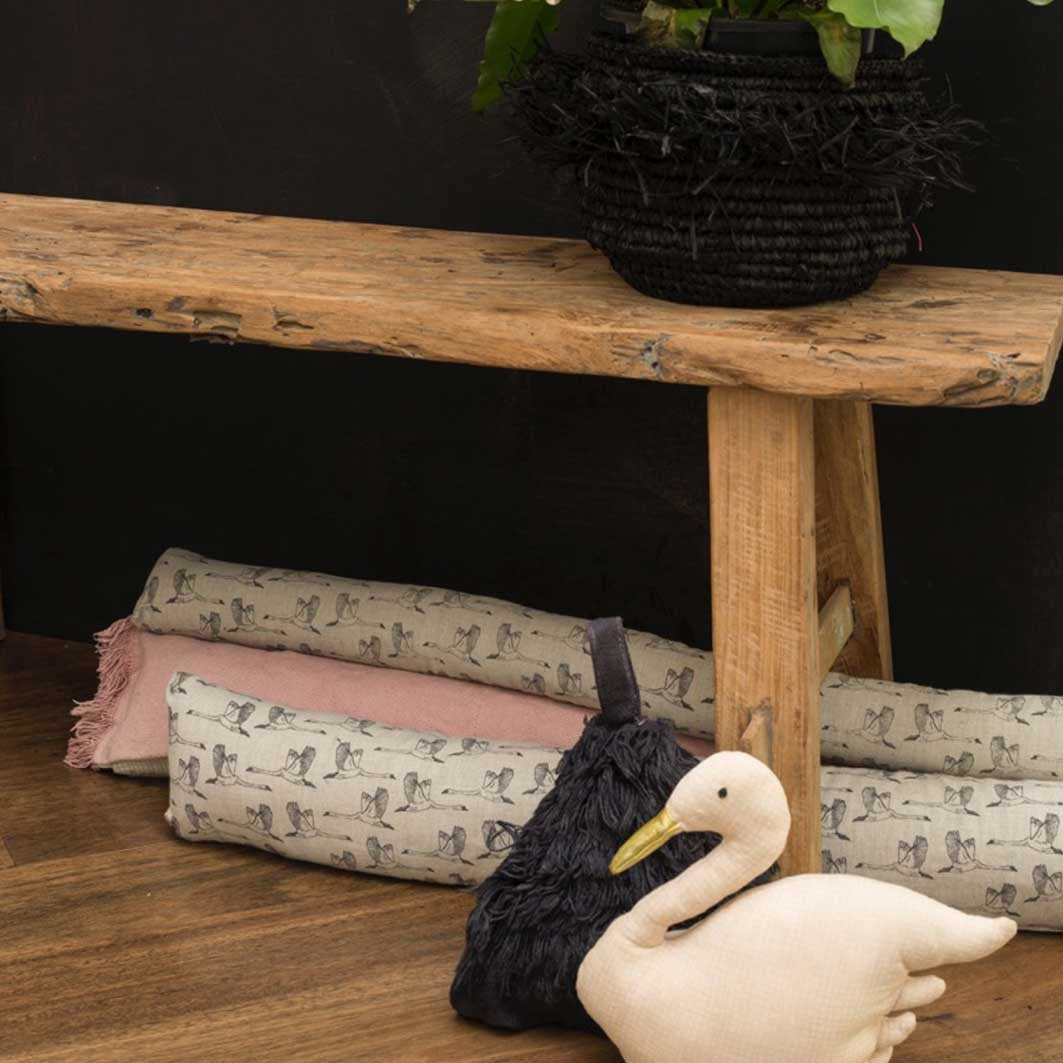 Grey draught excluder with flying geese design under wood bench